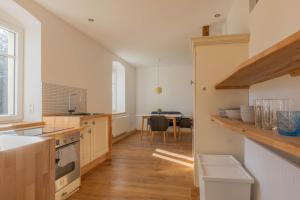 a kitchen with wooden floors and white walls and a table at Landstiltraum mit zwei Schlafzimmern zwischen L/DD in Mügeln