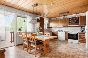 a kitchen with a large wooden table and chairs at Stadsnära och naturskön villa med 50m till vatten in Granträsket