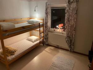 a bedroom with two bunk beds and a window at Stadsnära och naturskön villa med 50m till vatten in Granträsket