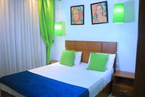 a bedroom with a bed with two green pillows at Madinty Stay in Madinaty