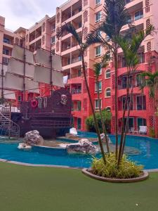 a pool with a pirate ship in front of a building at Seven Seas Condo Resort Jomtien in Jomtien Beach