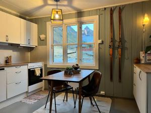 拉姆貝格的住宿－Lofoten Fjord House - Mountain & Seaview，厨房配有桌椅和窗户。