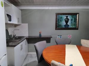 a kitchen with a wooden table and a dining room at RonVu @ Bertram in East London