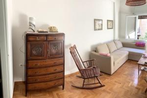 een woonkamer met een houten dressoir en een bank bij Sunny calm apartment in pedestrian street in Athene
