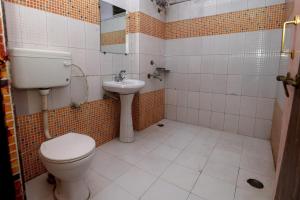 a bathroom with a toilet and a sink at Jain Residency in Pachmarhī