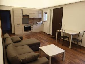 a living room with a couch and a table and a kitchen at BnB Rivera-Monteceneri in Rivera