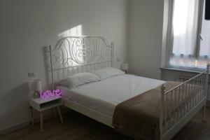 a bedroom with a white bed with a sign that says love at Le Tre Borghesi in Parma
