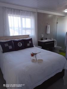 ein Schlafzimmer mit einem großen weißen Bett und einem Waschbecken in der Unterkunft Palm Tree in Kapstadt