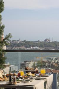 a table with food on a balcony with a view of the water at Fragments Hotel in Istanbul