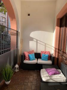 a patio with a couch and pillows on a balcony at Ferienwohnungen im Osteiner Hof in Mainz