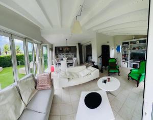 een woonkamer met witte meubels en groene stoelen bij Paradise in Le Gosier