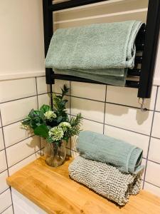 a table with a vase of flowers and towels at White Mermaid Cottage Anglesey Holidays in Newborough