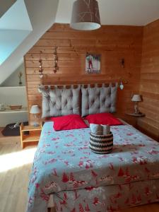 a bedroom with a large bed with red pillows at Ma Cabane du Canada in Combray