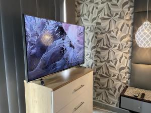 a flat screen tv sitting on top of a dresser at Calm Modern and Cosy Stay in Polokwane