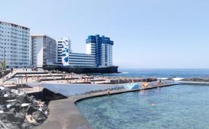 una piscina en una playa con gente en el agua en Salitre Suite 2, en Tacoronte