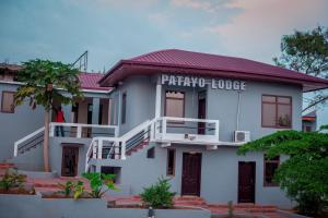 a white house with a sign that reads patriarchy house at PATAYO LODGE in Bantama