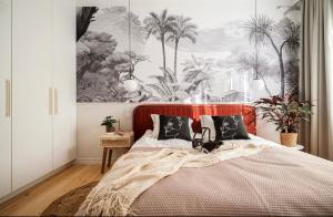 een slaapkamer met een bed met een schilderij van palmbomen bij Boutique 2 room apartment in center of Szczecin in Szczecin