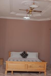 a bedroom with a bed with a ceiling fan at PATAYO LODGE in Bantama