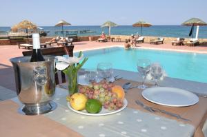 a table with a plate of fruit next to a pool at Manolya Hotel in Kyrenia