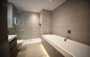 a bathroom with a tub and a toilet and a sink at Taransay House, Small Hotel in Portree