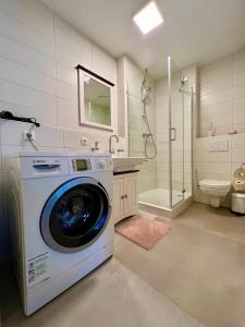 a washing machine in a bathroom with a shower at Apartment Beethoven by Aux Property in Augsburg