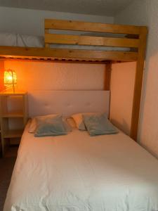 a bed with two pillows on it in a room at Studio de 32 m2 pour 3 personnes pied des pistes in Les Deux Alpes