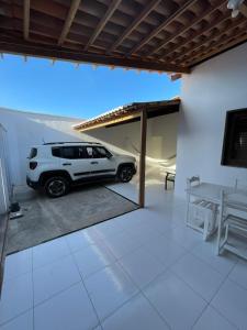 une voiture blanche garée à l'intérieur d'une maison dans l'établissement Casa Camocim, à Camocim