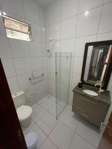 a bathroom with a toilet and a sink and a shower at Casa Camocim in Camocim