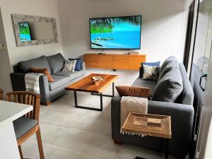 sala de estar con 2 sofás y TV en New! A little piece of Pura Vida - Casa Yara, en Jacó
