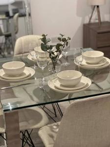 a glass table with plates and wine glasses on it at Modern Studio in popular South Kensington location in London