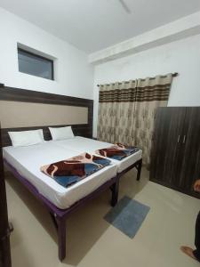 a bedroom with a bed in a room at M Cube Service Apartments in Sakleshpur