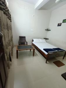 a bedroom with a bed and a coffee table at M Cube Service Apartments in Sakleshpur
