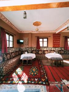 a living room with two tables and a couch at auberge restaurant tizgui in Tinerhir
