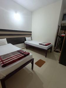 a room with two beds and a table and a bed at M Cube Service Apartments in Sakleshpur