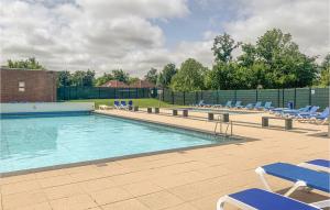 a swimming pool with blue lounge chairs at Beautiful Home In Herkingen With Wifi, 2 Bedrooms And Outdoor Swimming Pool in Herkingen