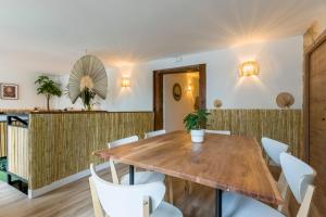 ein Esszimmer mit einem Holztisch und weißen Stühlen in der Unterkunft Santo - Coworking - Coliving - Madrid in Madrid