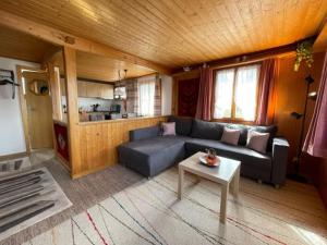 ein Wohnzimmer mit einem Sofa und einem Tisch in der Unterkunft Chalet Chutzli in Axalp