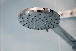 a shower head in a bathroom with a blue wall at Sublime appartement à Cocody Riviera Bonoumin . in Abidjan