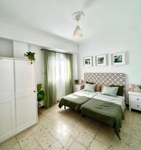 a white bedroom with a bed and a window at Big spacious penthouse next to the sea in Valencia