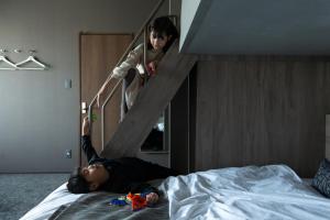 a person is laying on a bed with a staircase at fav KAGOSHIMA CHUO in Kagoshima