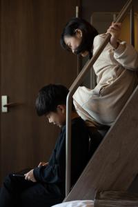 a man and a woman sitting on a bunk bed at FAV HOTEL KAGOSHIMACHUO in Kagoshima