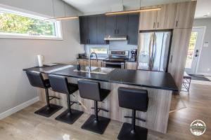 - une cuisine avec un plan de travail noir et un évier dans l'établissement Les Rois de la Montagne, à Saint-Jean-de-Matha