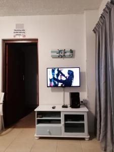 sala de estar con TV de pantalla plana en la pared en Seeskulp 18, en Margate