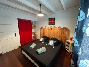 1 dormitorio con 1 cama grande y cortina roja en Villa Soualiga Orient Bay en Saint Martin