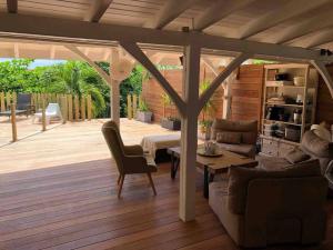 a living room with a wooden deck with a pergola at Villa Soualiga Orient Bay in Saint Martin