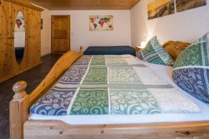 een slaapkamer met een bed met een quilt bij Ferienwohnung Jasmin in Wieden