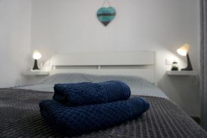 ein Bett mit zwei blauen Kissen darüber in der Unterkunft Blue Ocean Corralejo: Sunny terrace, pool, wifi in Corralejo