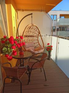 balkon ze stołem, krzesłami i kwiatami w obiekcie Apartament FALA-Miodowy Dom w Kołobrzegu