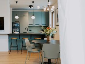 a kitchen with blue cabinets and a table and chairs at Apartament Szyperska 23 Stare Miasto in Poznań