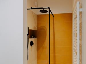 a shower in a bathroom with yellow walls at Apartament Szyperska 23 Stare Miasto in Poznań